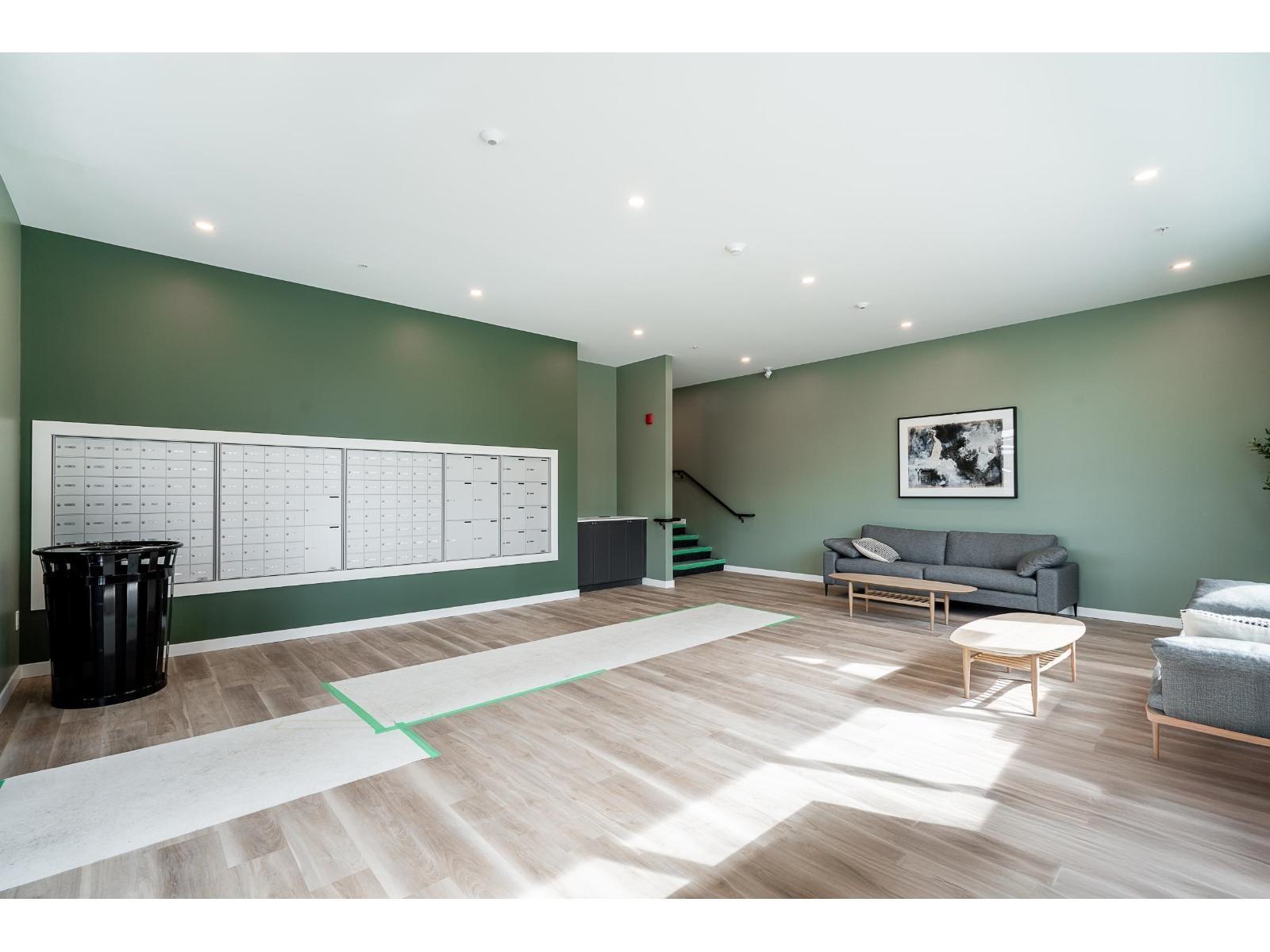 A living room with a couch, coffee table, and a calendar on the wall.