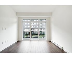 A room with a large window and wooden flooring.