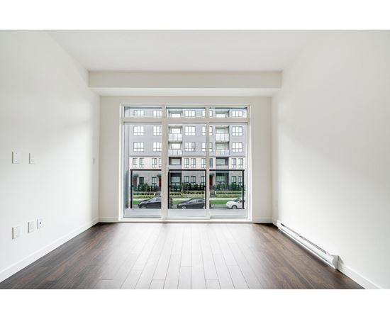 A room with a large window and wooden flooring.