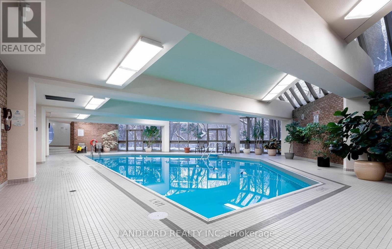 A large indoor swimming pool with a tiled floor.
