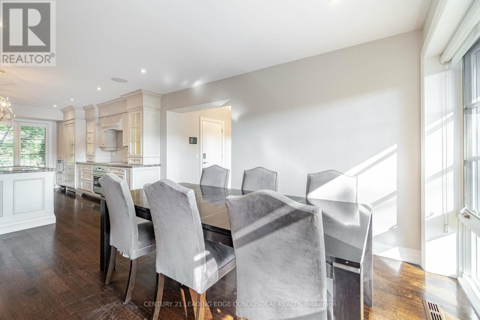 A dining room with a large table and chairs.