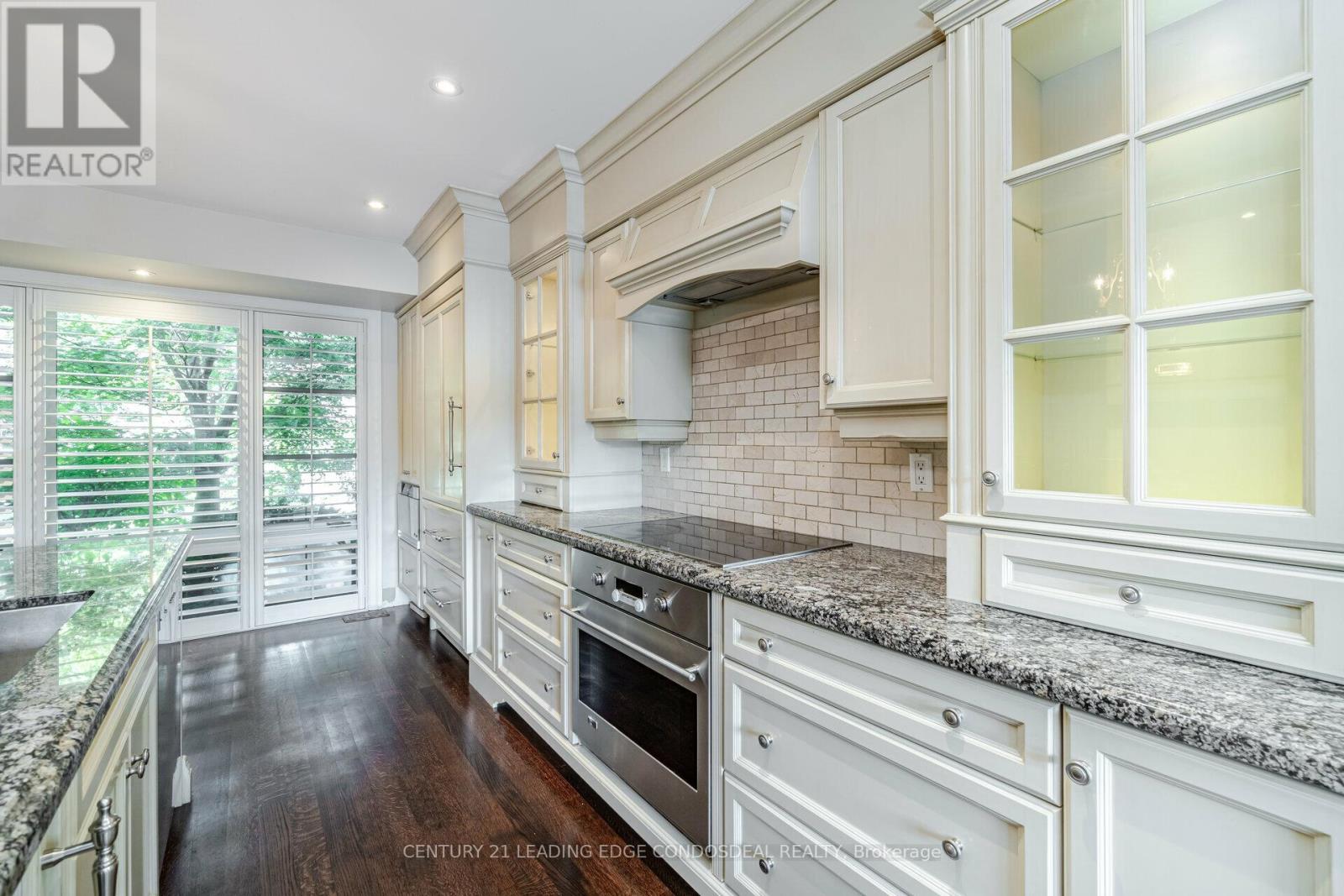 A modern kitchen with white cabinets and a granite countertop.
