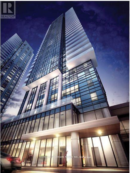 A tall building with a glass facade and a car parked in front of it.