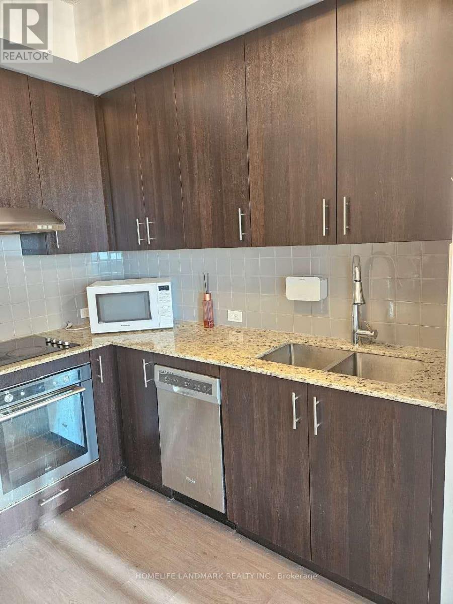 A kitchen with brown cabinets and a white microwave.
