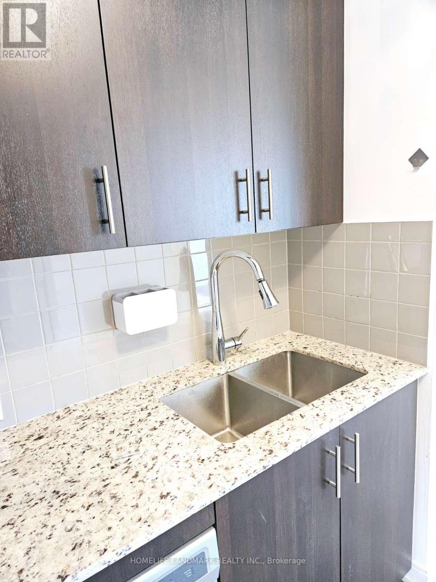 A kitchen with a granite counter top and a sink.