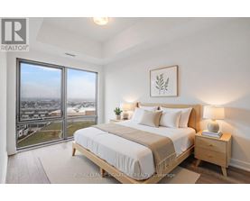 A bedroom with a large bed and a view of the city.