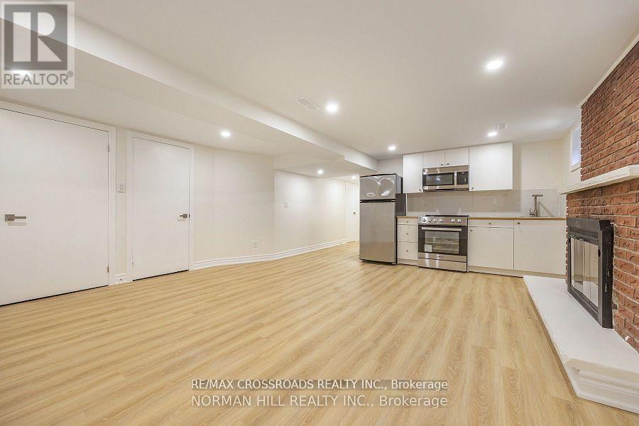 A spacious kitchen with wooden flooring and modern appliances.