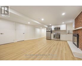 A spacious kitchen with wooden flooring and modern appliances.