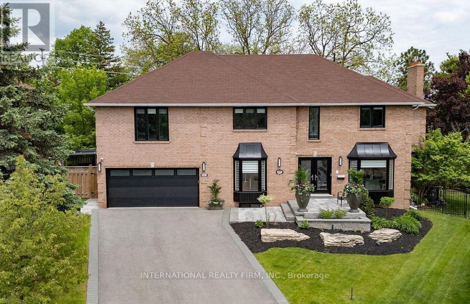 A house with a brick facade and a black garage door is for sale.