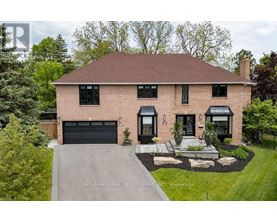 A house with a brick facade and a black garage door is for sale.