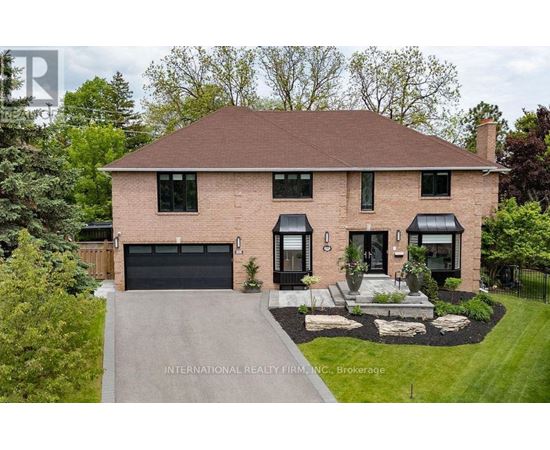 A house with a brick facade and a black garage door is for sale.