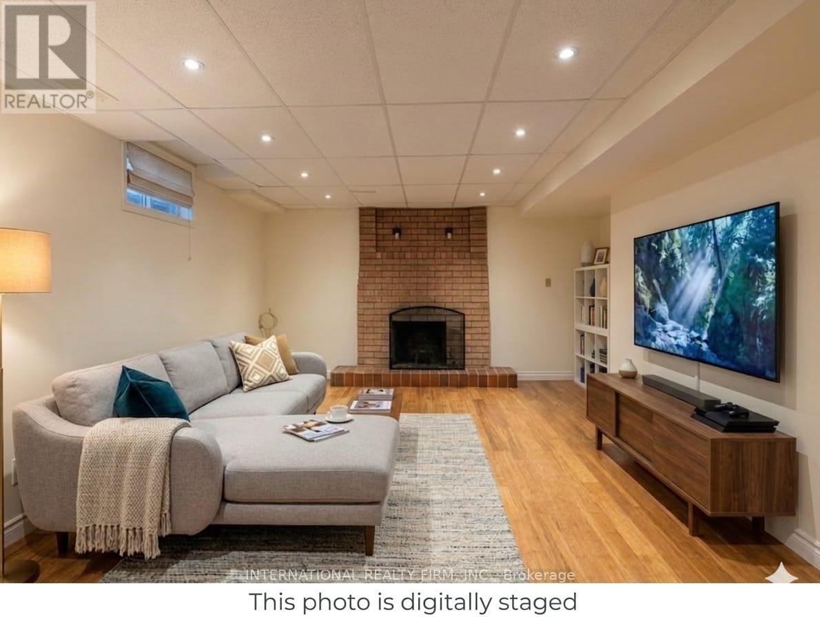 A living room with a grey couch, a fireplace, and a television.