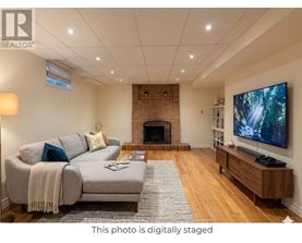 A living room with a grey couch, a fireplace, and a television.