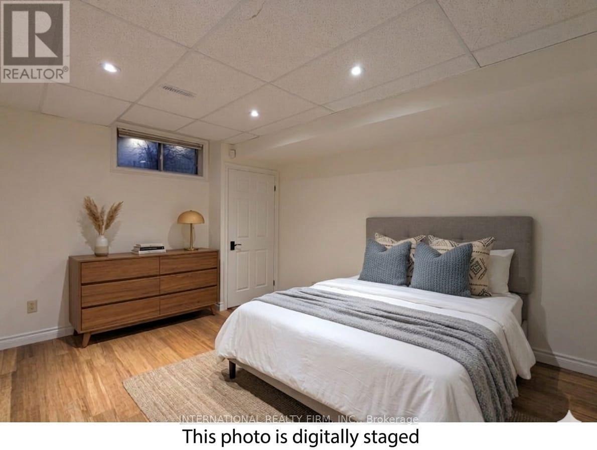 A bedroom with a bed, dresser, and window.