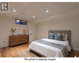 A bedroom with a bed, dresser, and window.