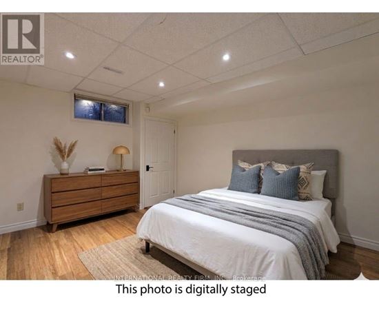 A bedroom with a bed, dresser, and window.