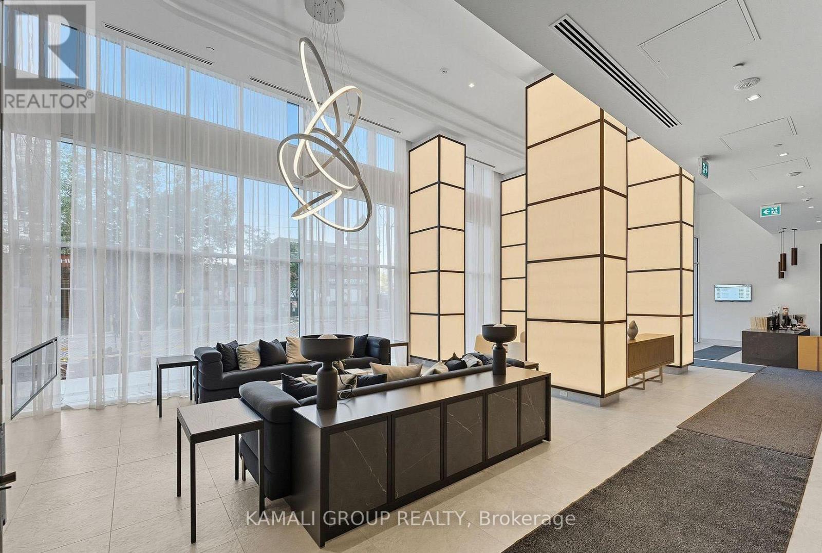 A modern office space with a reception desk and a large window with curtains.