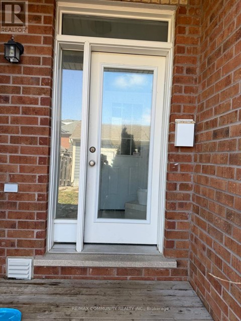 A white door with a glass window is set in a brick wall.