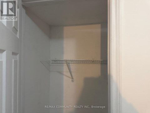 A staircase with a white wall and a red jacket hanging on the railing.