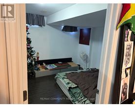 A bedroom with a bed, a Christmas tree, and a fan.