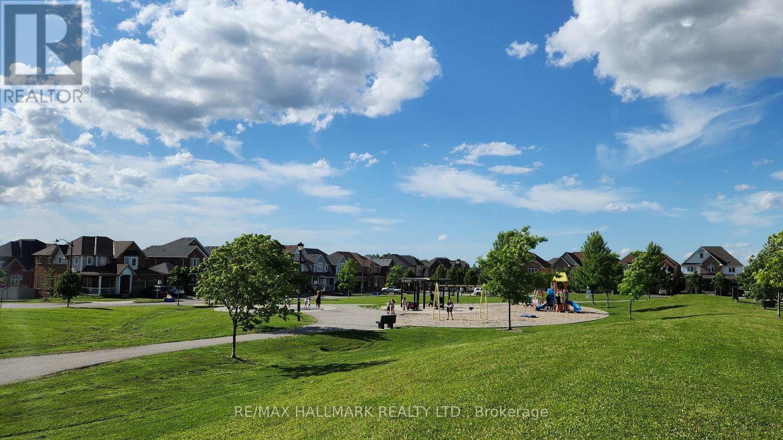 A park with a playground and houses in the background.
