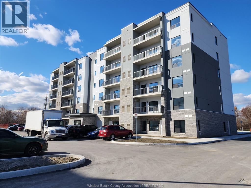 A large apartment building with a parking lot in front.