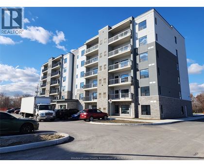A large apartment building with a parking lot in front.