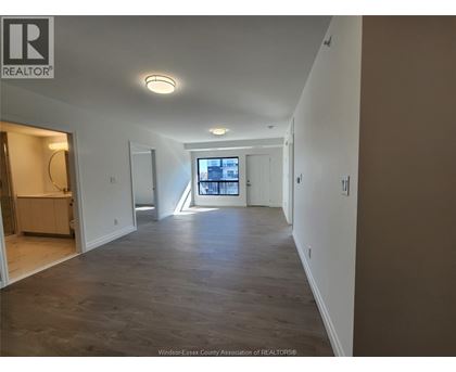 A spacious room with a large window and a view of the city.