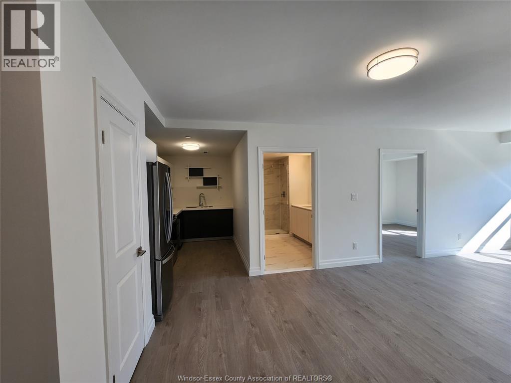 A spacious room with wooden flooring and white walls.
