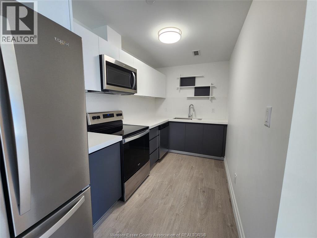 A kitchen with a stainless steel refrigerator and microwave.