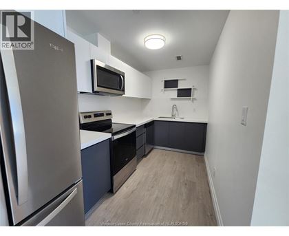A kitchen with a stainless steel refrigerator and microwave.
