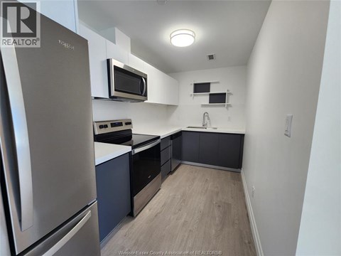 A kitchen with a stainless steel refrigerator and microwave.