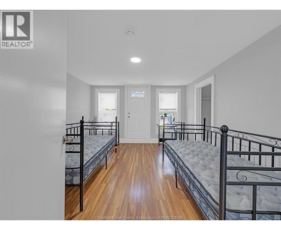 A bedroom with two beds and a door.