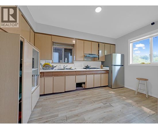 A kitchen with wooden cabinets and a refrigerator.