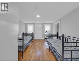 A bedroom with two beds and a door.