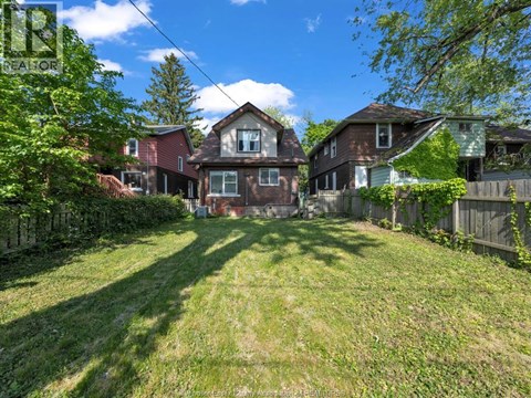 A sunny day in a residential area with houses and green lawns.