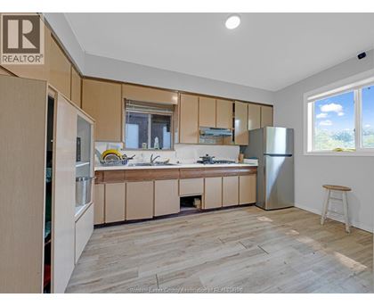 A kitchen with wooden cabinets and a refrigerator.