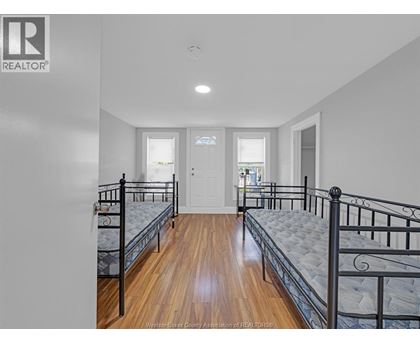 A bedroom with two beds and a door.