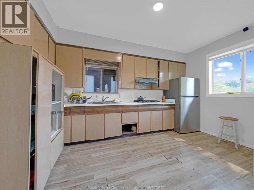 A kitchen with wooden cabinets and a refrigerator.