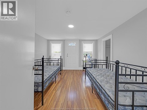 A bedroom with two beds and a door.