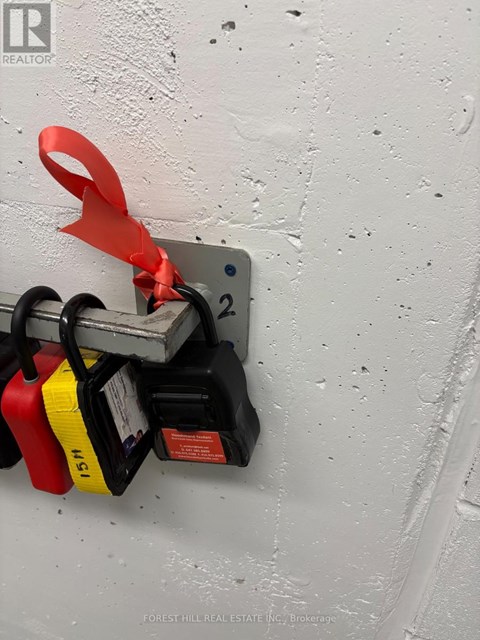 A red, yellow and black object is plugged into a white wall socket.