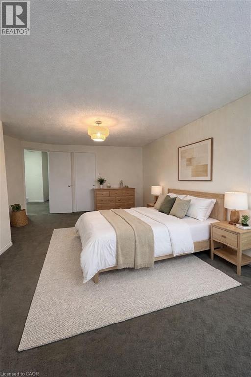 A bedroom with a bed, nightstand, and a rug.