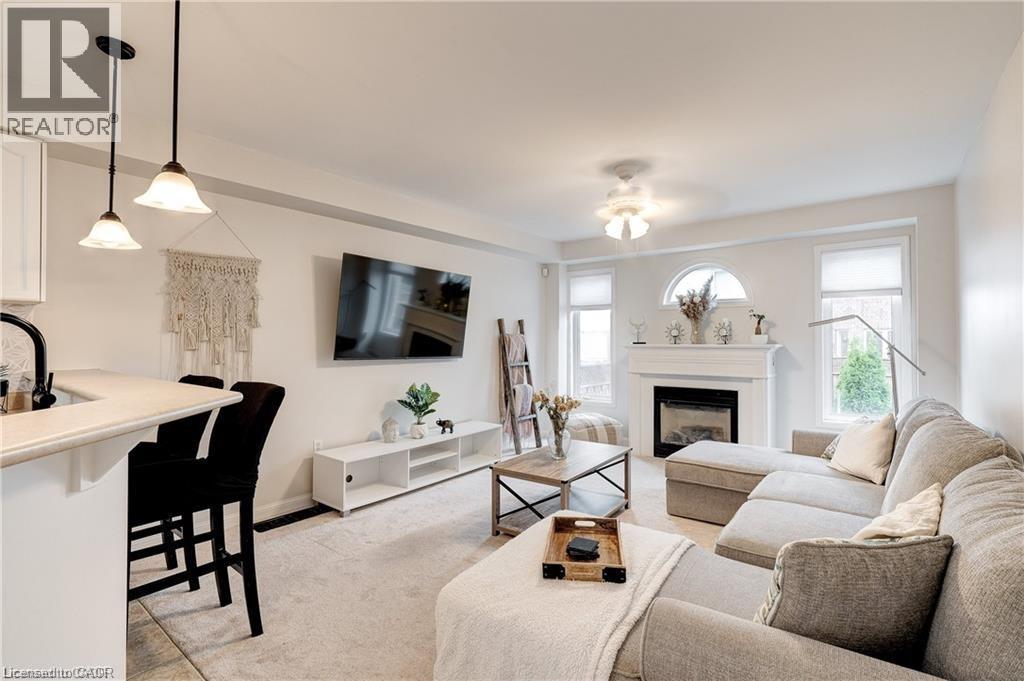 A living room with a fireplace and a television mounted on the wall.