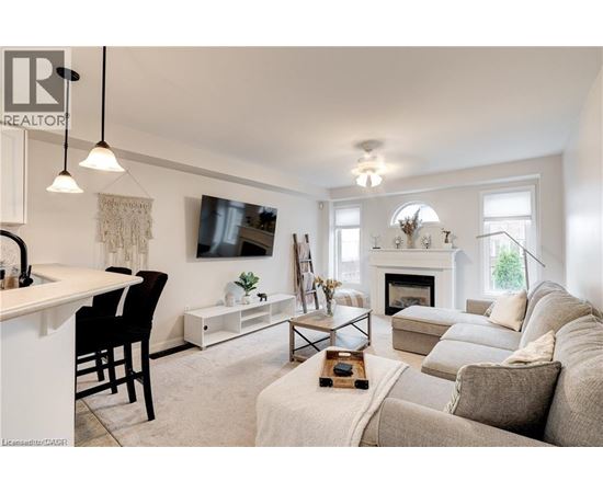 A living room with a fireplace and a television mounted on the wall.