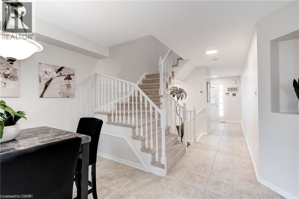A spacious hallway with a staircase and a dining table.