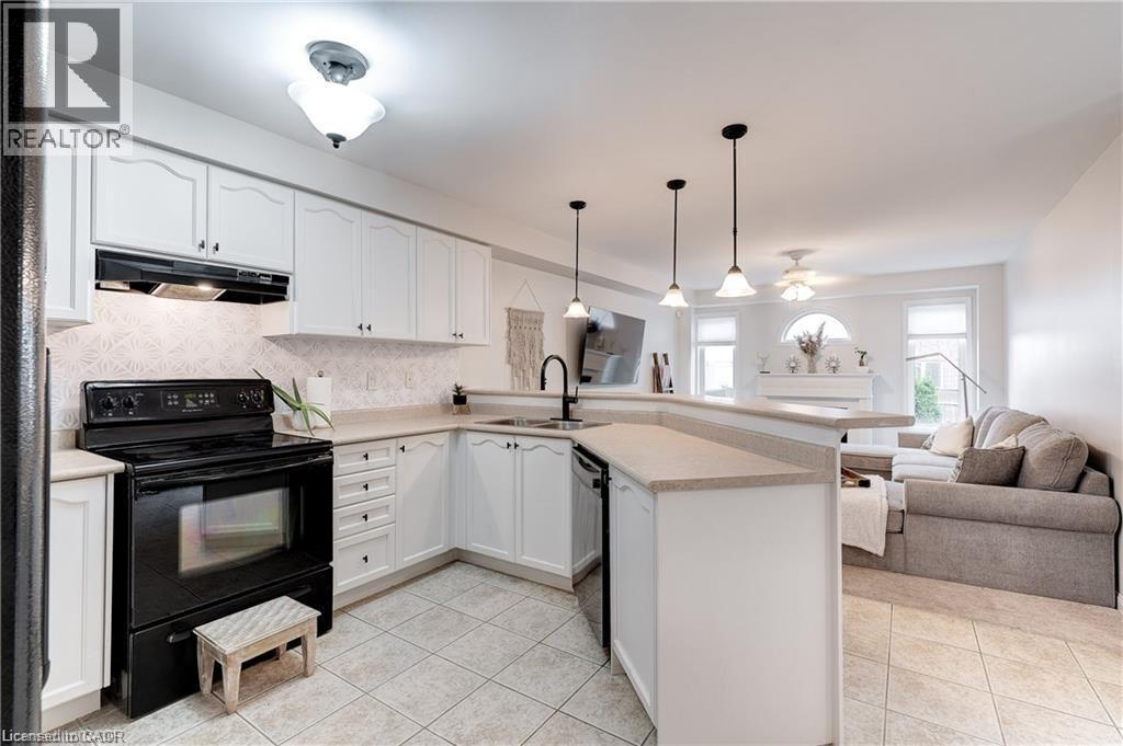A kitchen with white cabinets and a black stove top oven.