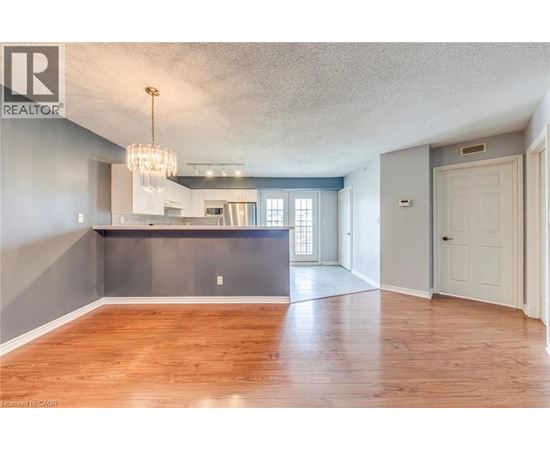 A spacious living room with hardwood floors and a large window.