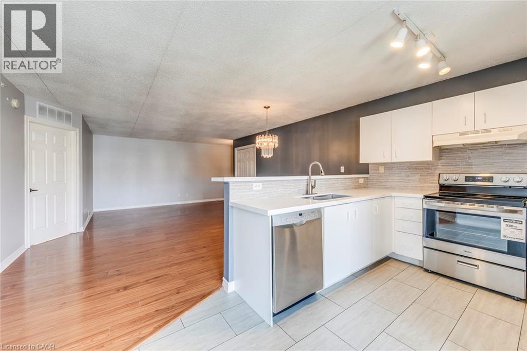 A kitchen with white cabinets and a wooden floor.