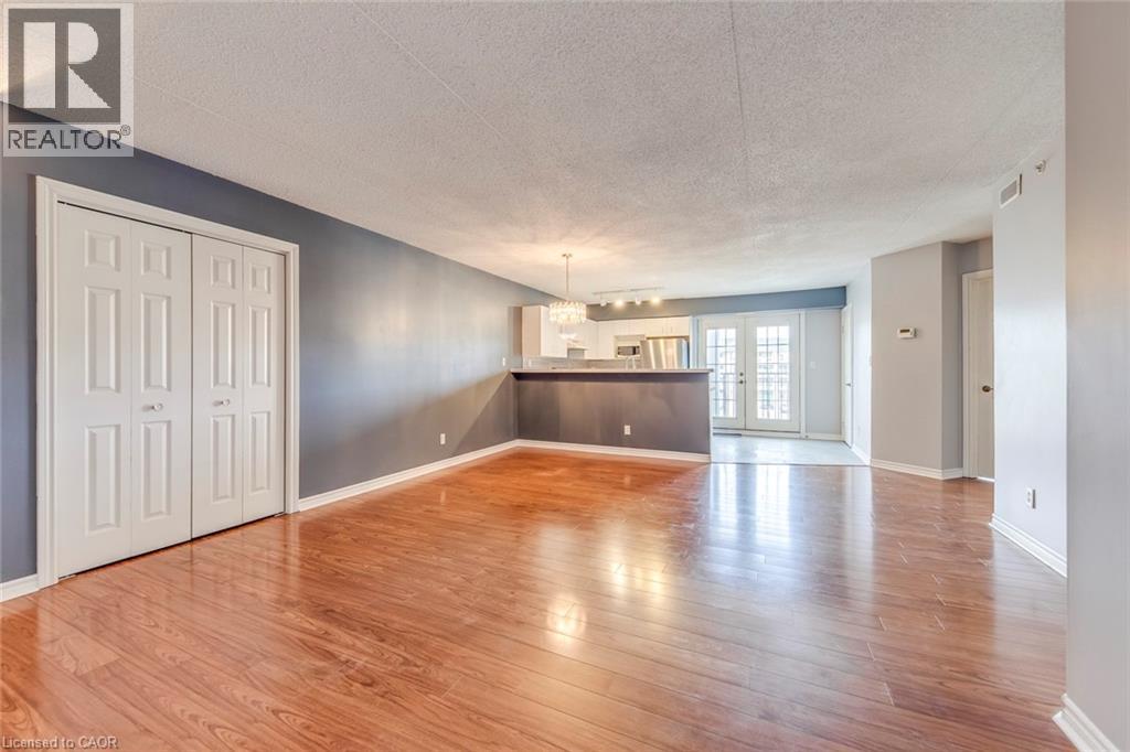 A spacious room with wooden floors and a large window.