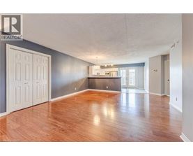 A spacious room with wooden floors and a large window.